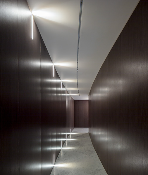 Elegantly curved corridor features minimalist details and wood panelling, 07 of 08.